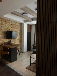 a room with a desk and a tv on a brick wall at Mountain Hearth - Milmari Resort in Kopaonik