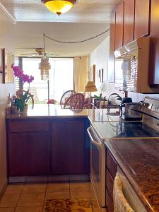 una cucina con piano di lavoro e una grande finestra di Maalaea Oceanfront Condo a Wailuku