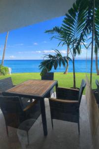 un tavolo e sedie in legno con vista sull'oceano di Maalaea Oceanfront Condo a Wailuku