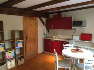 a kitchen with red cabinets and a white table and chairs at Apartment Kastanienblick by Interhome in Ziethen