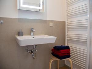 a bathroom with a sink and a pile of towels at Apartment im Illertal by Interhome in Altenstadt +5 photos