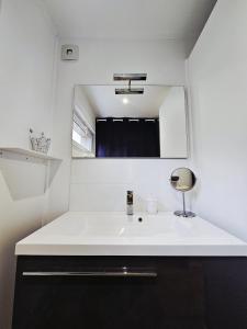 un bagno con un lavandino bianco e uno specchio di L'Annexe Privative a Roquemaure