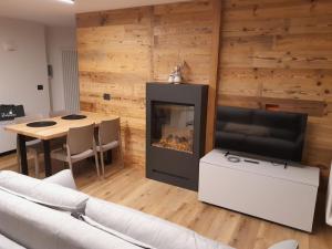 a living room with a fireplace and a table at Casa Zena in Tesero