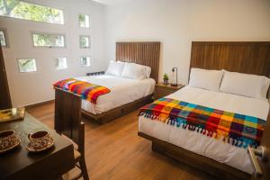 a bedroom with two beds with a colorful blanket at La Casa del Mural - Suites Condesa in Mexico City