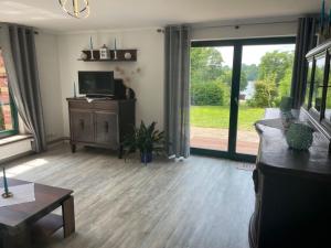 a living room with a couch and a television at Apartment am Wurlsee by Interhome in Lychen