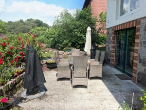 a patio with chairs and an umbrella and flowers at Apartment am Wurlsee by Interhome in Lychen