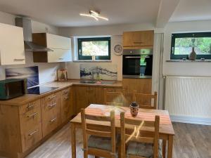 a kitchen with wooden cabinets and a wooden table with chairs at Apartment am Wurlsee by Interhome in Lychen +13 photos
