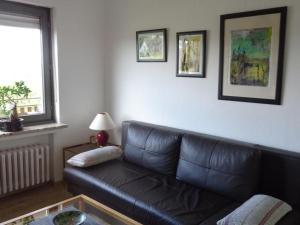 a living room with a black leather couch and a table at Apartment Jakobs by Interhome in Vlotho