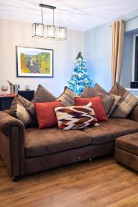 een bank met kussens en een kerstboom in een woonkamer bij The Hideaway in Durham