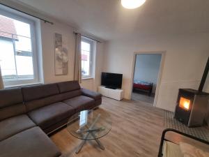 een woonkamer met een bank en een open haard bij Vienna Gateway - Self Check-In 24 - free parking in Bockfließ