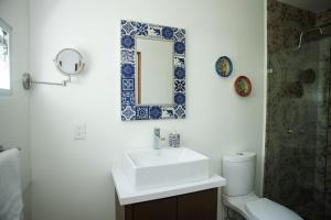 a bathroom with a sink and a mirror and a toilet at La Casa del Mural - Suites Condesa in Mexico City