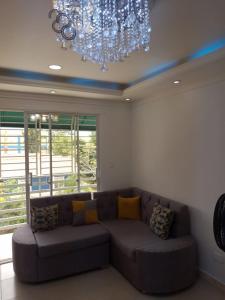 a large couch in a living room with a chandelier at Alojamiento M&M in Los Paredones