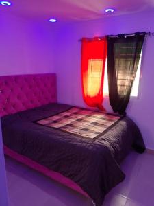 a purple room with a bed with two lights on it at Alojamiento M&M in Los Paredones