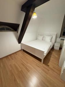 une chambre avec un lit blanc et un parquet dans l'établissement Luxury 3-room house, à Illkirch-Graffenstaden