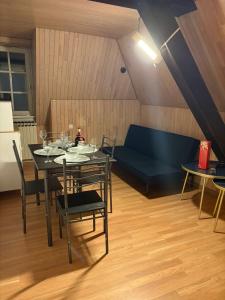 une salle à manger avec une table et un canapé bleu dans l'établissement Luxury 3-room house, à Illkirch-Graffenstaden