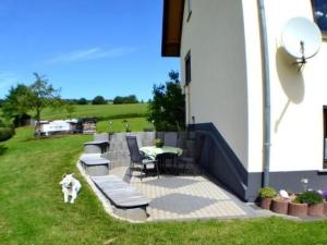 a dog standing on a patio with a table and chairs at Apartment Haus-Trapp by Interhome in Unterbernhards