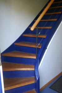 a set of stairs with blue paint and a wooden rail at Holiday Home Buschle by Interhome in Tettnang
