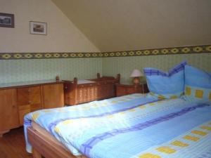 a bedroom with a large bed with a blue comforter at Holiday Home Buschle by Interhome in Tettnang