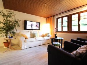 a living room with a white couch and a tv at Apartment Bemer-Rempfler by Interhome in Bürglen