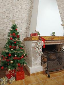 een kerstboom in een woonkamer naast een open haard bij Señorío de Ves in Casas de Ves