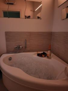 een bad in de badkamer met een fles champagne bij Apulian Dreams in Brindisi