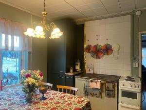 a kitchen with a table with a vase of flowers on it at Atelier Torppa in Rovaniemi +8 photos