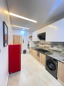 eine Küche mit einem roten Kühlschrank in einem Zimmer in der Unterkunft 2-Bedroom Apartment with Pool, Gym, Snooker & Table Tennis in Lekki Ajah in Lekki