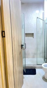 ein Badezimmer mit Glasdusche und Toilette in der Unterkunft 2-Bedroom Apartment with Pool, Gym, Snooker & Table Tennis in Lekki Ajah in Lekki + 15 Fotos