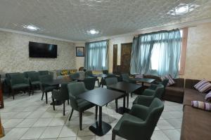 een wachtkamer met tafels en stoelen en een tv bij HOTEL VELLEDA in Rabat