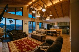 a living room with couches and a kitchen with a table at Chalet Village Bran in Bran
