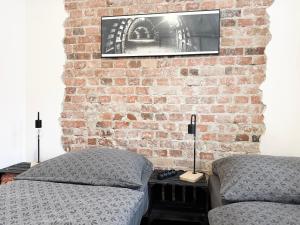 una camera da letto con due letti e un muro di mattoni di Apartament Kopalniok a Zabrze