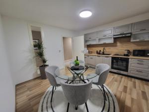 a kitchen with a table and chairs in a room at KRUNA Apartment in Cazin +8 photos