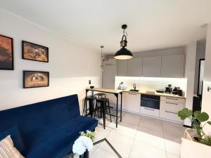 un soggiorno con un divano blu e una cucina di Apartament Kopalniok a Zabrze Altre 23 foto