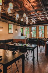 een eetkamer met tafels, stoelen en kroonluchters bij Hotel Montfort in Nicolet