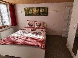a small bedroom with a bed with a red and white blanket at Apartment GLORIOS by Interhome in Heiden