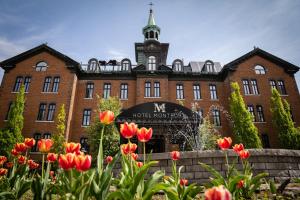a large red brick building with a clock tower at Hotel Montfort in Nicolet