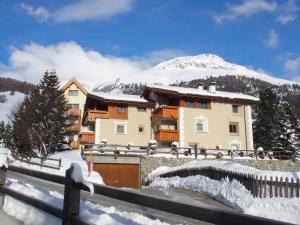 a house in the snow with a mountain in the background at Apartment Aivla by Interhome in Celerina
