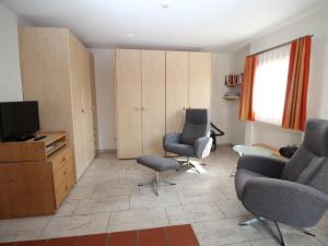 a living room with two chairs and a television at Apartment Aivla by Interhome in Celerina