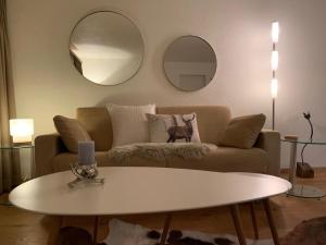 a living room with a couch and a table and mirrors at Apartment Chäserruggblick by Interhome in Unterwasser