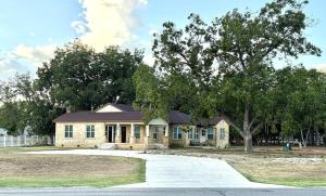 een huis met een boom ervoor bij River Side Private Retreat in Seguin