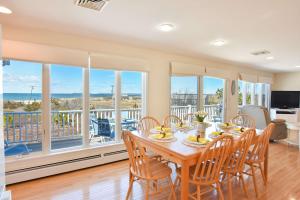 una sala da pranzo con tavolo e sedie e un balcone di Stunning Water Views by Private Beach a Eastham