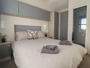 een slaapkamer met een groot wit bed met handdoeken erop bij Meadows Park 4 in Hull
