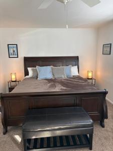 a bedroom with a large wooden bed with a bench at Desert Vista View in Desert Hot Springs +63 photos