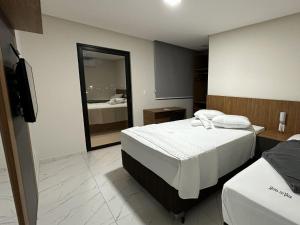una stanza d'albergo con un letto e uno specchio di Hotel do Vale a Petrolina