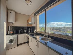 a kitchen with a sink and a large window at Prestigia Argan 2Ch Piscine et Parking 6pax in Marrakech