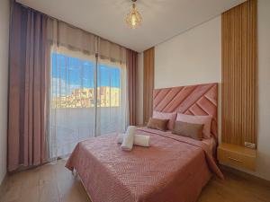 a bedroom with a large bed with a large window at Prestigia Argan 2Ch Piscine et Parking 6pax in Marrakech +62 photos