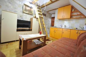 a living room with a kitchen and a ladder in a room at Apartmani Nikcevic Zabljak in Virak