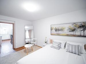 een witte slaapkamer met een groot wit bed en een bureau bij Grand Family Residence Ljubljana in Ljubljana