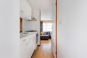 a kitchen with white cabinets and a stove top oven at Gezellige chalet in Lithse Ham in Lith