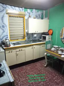 een keuken met witte kasten, een wastafel en een tafel bij Captain Morgan House in Kingston +35 foto's